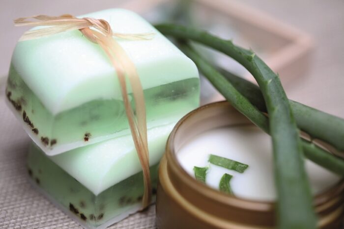 Handmade soap bars, aloe, vera leaves and moisturizer.